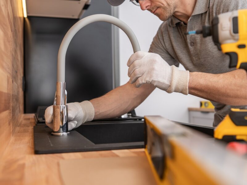 Plumber Installing Kitchen Sink and a Faucet